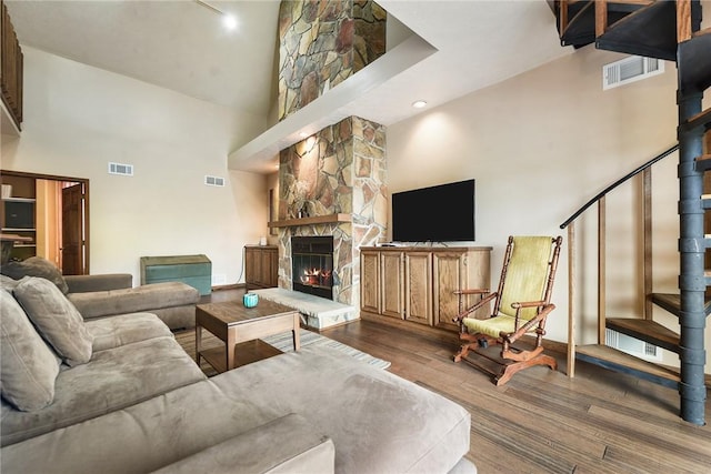 1521 Claim St, Troy Hill, PA 15212 - living room featuring a towering ceiling, wood finished floors, a stone fireplace, and stairs