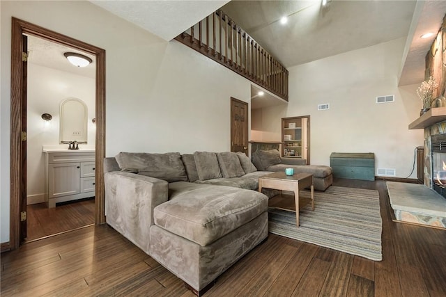1521 Claim St, Troy Hill, PA 15212 - living room with a multi sided fireplace, dark wood-style floors, baseboards, and a towering ceiling