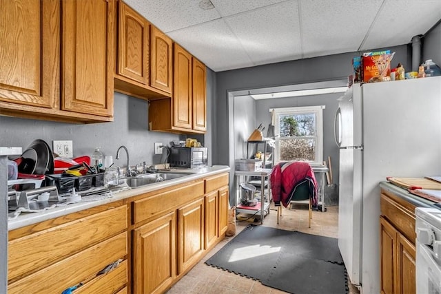 1303 Alton St, Beechview, PA 15216 - kitchen with freestanding refrigerator, light countertops, brown cabinets, a sink, and a drop ceiling