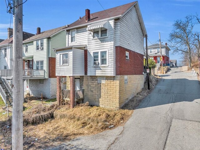 1303 Alton St, Beechview, PA 15216 - rear view of house with a chimney, a residential view, brick siding, driveway, and cooling unit