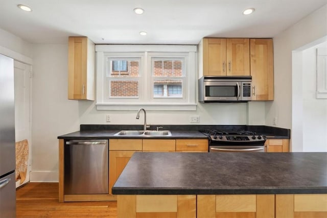 5465 Coral St, Friendship Park, PA 15206 - kitchen featuring appliances with stainless steel finishes, a sink, dark countertops, light wood-style floors, and recessed lighting