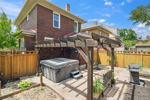 5465 Coral St, Friendship Park, PA 15206 - back of property featuring a hot tub, brick siding, a patio, and a fenced backyard