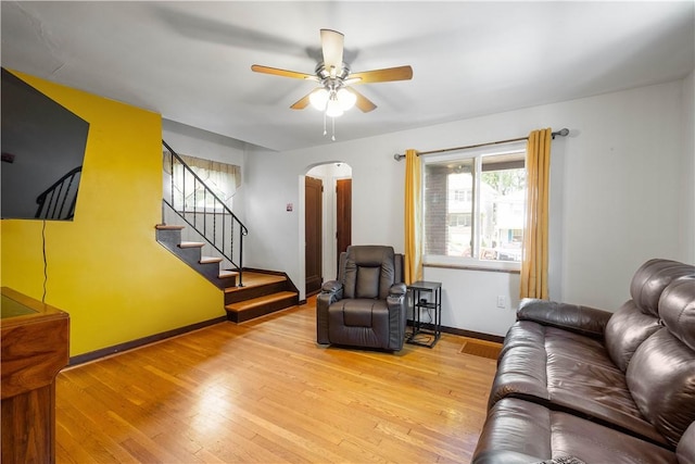 1415 Oakglen St, Crafton Heights, PA 15204 - living room featuring ceiling fan, arched walkways, light wood-type flooring, stairs, and baseboards