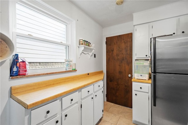 1415 Oakglen St, Crafton Heights, PA 15204 - kitchen featuring freestanding refrigerator, white cabinets, light countertops, and light tile patterned flooring