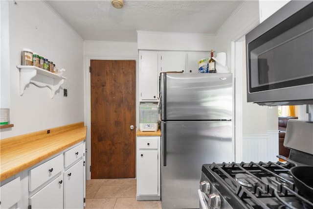 1415 Oakglen St, Crafton Heights, PA 15204 - kitchen featuring appliances with stainless steel finishes, white cabinetry, light countertops, ornamental molding, and light tile patterned flooring