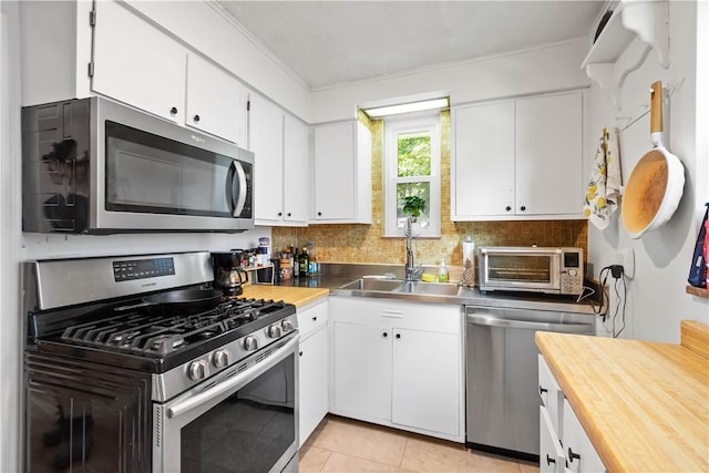 1415 Oakglen St, Crafton Heights, PA 15204 - kitchen with stainless steel appliances, stainless steel counters, a sink, white cabinetry, and ornamental molding