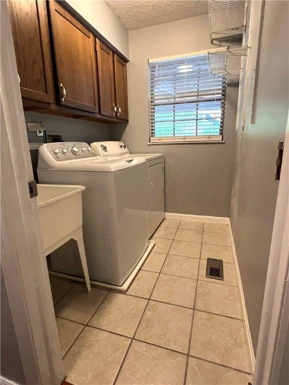 758 Venango Ave, Shaler, PA 15209 - washroom with separate washer and dryer, cabinet space, a textured ceiling, light tile patterned floors, and baseboards