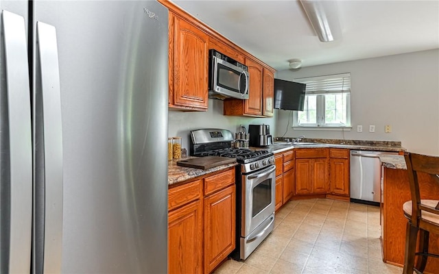 411 Fairgate, Pine Twp, PA 15090 - kitchen with stainless steel appliances, brown cabinetry, and dark stone countertops