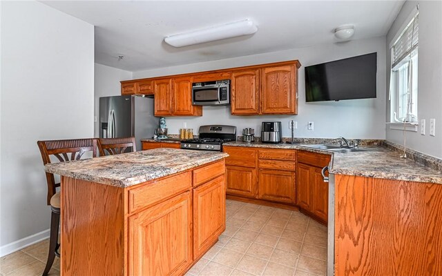 411 Fairgate, Pine Twp, PA 15090 - kitchen featuring appliances with stainless steel finishes, a kitchen breakfast bar, a kitchen island, brown cabinetry, and light tile patterned floors