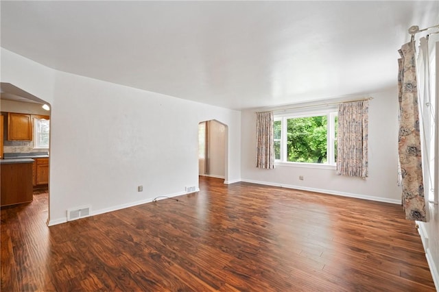 2501 Middletown Rd, Ingram, PA 15205 - unfurnished living room with arched walkways, dark wood finished floors, and baseboards
