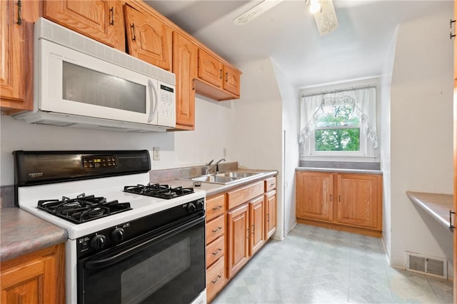 2501 Middletown Rd, Ingram, PA 15205 - kitchen with white microwave, gas stove, a sink, light floors, and light countertops