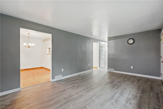 124 Plum St, Franklin Twp, PA 16117 - empty room with wood finished floors, a chandelier, and baseboards