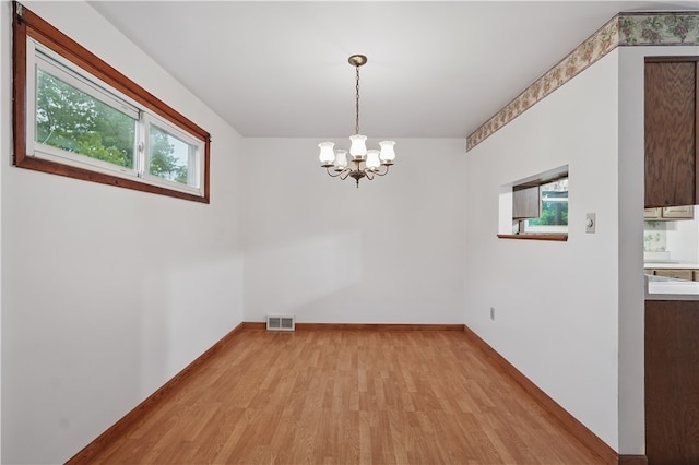 124 Plum St, Franklin Twp, PA 16117 - unfurnished dining area with plenty of natural light, light wood finished floors, a chandelier, and baseboards