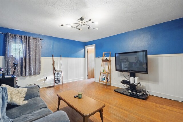 627 Seminary Ave, South Fayette, PA 15071 - living room with a textured ceiling, a chandelier, wood-type flooring, and wainscoting