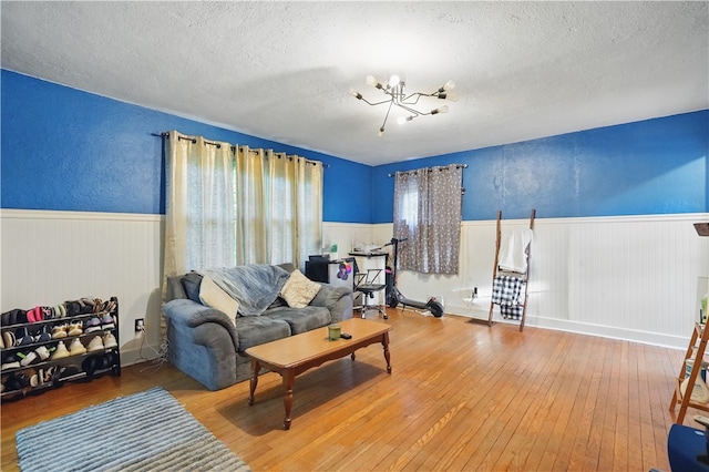 627 Seminary Ave, South Fayette, PA 15071 - living area with a textured ceiling, wainscoting, wood-type flooring, and a chandelier