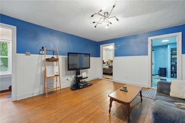 627 Seminary Ave, South Fayette, PA 15071 - living room featuring a textured ceiling, hardwood / wood-style floors, a chandelier, wainscoting, and a textured wall