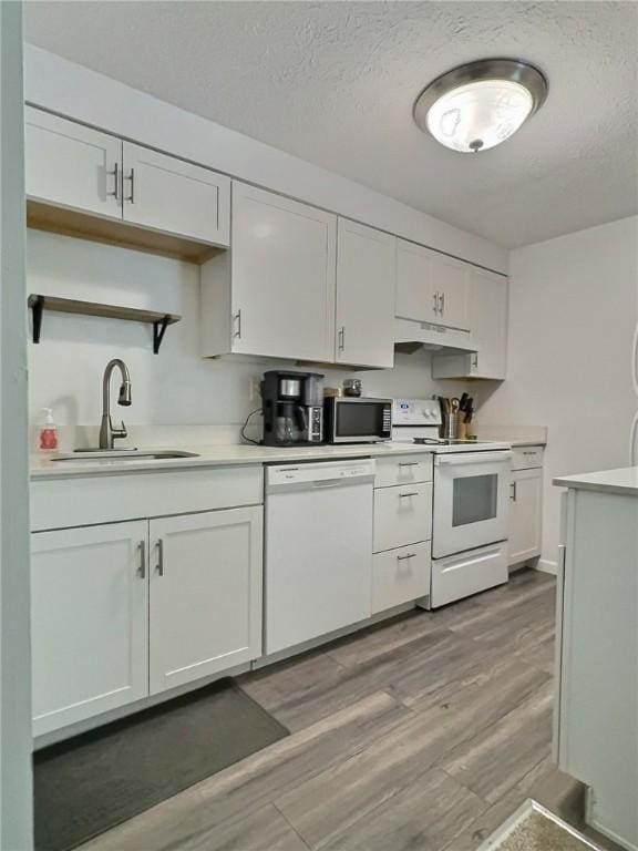 2465 Brook Ledge Rd Unit 31A, South Fayette, PA 15017 - kitchen featuring white appliances, a sink, light countertops, white cabinets, and light wood-style flooring