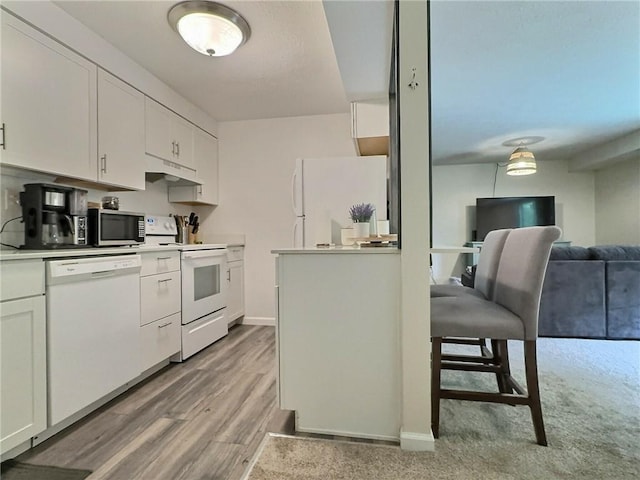 2465 Brook Ledge Rd Unit 31A, South Fayette, PA 15017 - kitchen with white appliances, under cabinet range hood, white cabinetry, light countertops, and wood finished floors