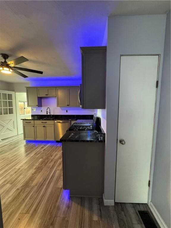 2422 Salisbury St, South Side, PA 15210 - kitchen featuring stainless steel appliances, a sink, dark countertops, ceiling fan, and wood finished floors
