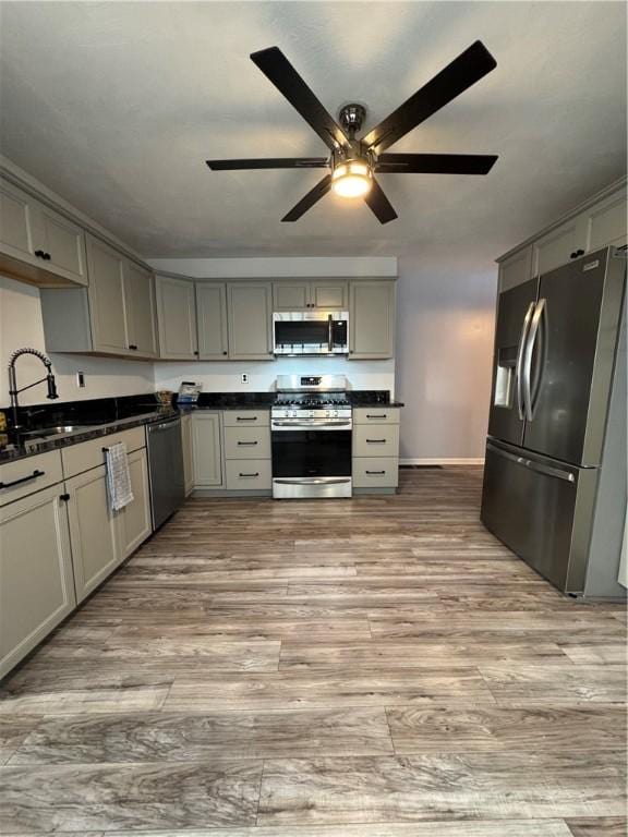 2422 Salisbury St, South Side, PA 15210 - kitchen with appliances with stainless steel finishes, gray cabinetry, dark countertops, a ceiling fan, and a sink