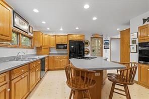 208 Kozy Cor, Middlesex Twp, PA 16059 - kitchen with black appliances, a breakfast bar, a kitchen island, recessed lighting, and light floors