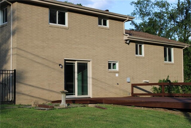 1502 Orchard Dr, Unity Twp, PA 15601 - rear view of house featuring brick siding, a yard, and a wooden deck