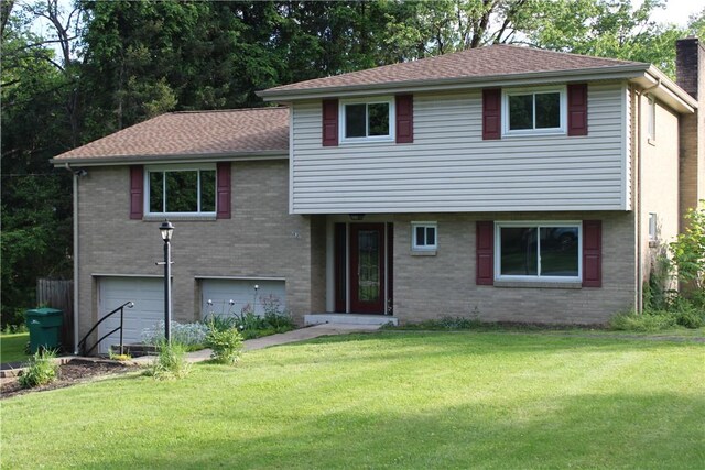 1502 Orchard Dr, Unity Twp, PA 15601 - tri-level home featuring an attached garage, a front yard, brick siding, and a chimney