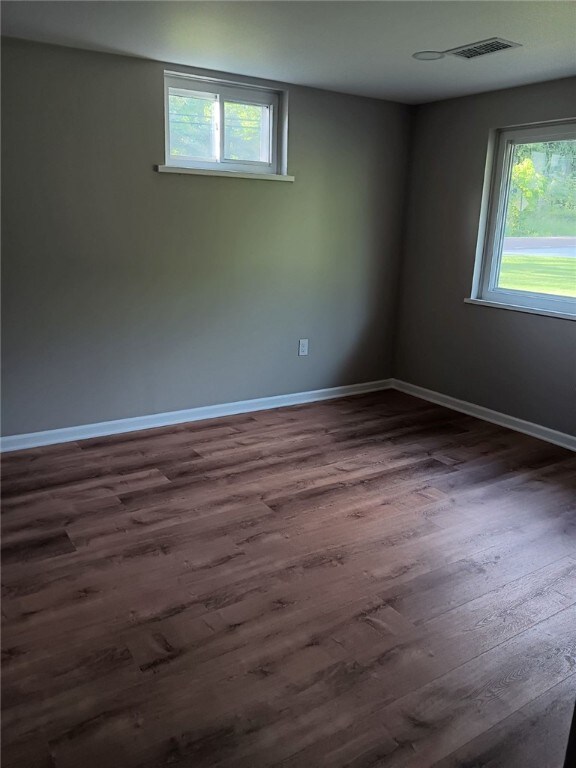1502 Orchard Dr, Unity Twp, PA 15601 - empty room featuring healthy amount of natural light, dark wood-style flooring, and baseboards