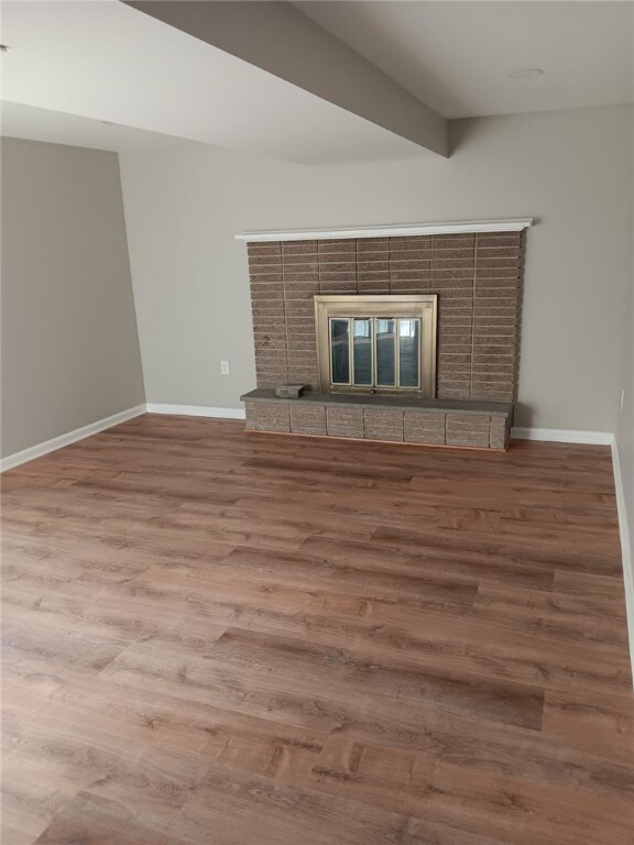 1502 Orchard Dr, Unity Twp, PA 15601 - unfurnished living room featuring a tile fireplace, wood finished floors, and baseboards