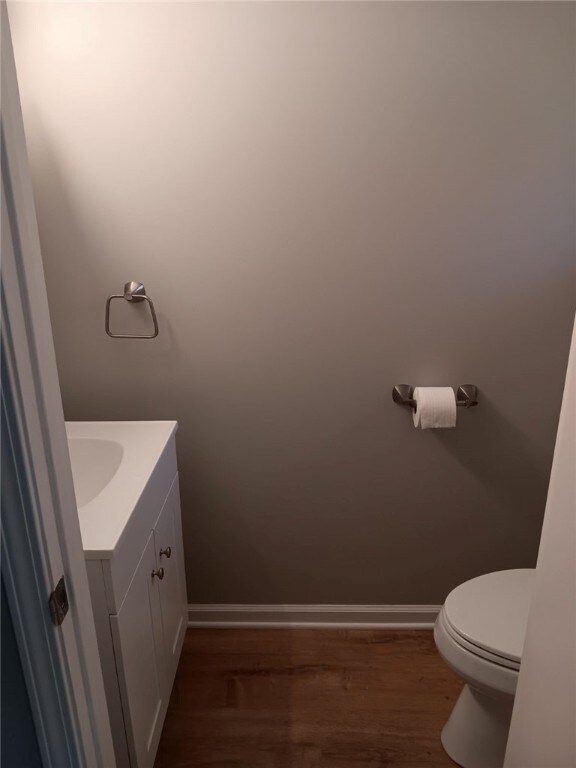 1502 Orchard Dr, Unity Twp, PA 15601 - bathroom with vanity, toilet, wood finished floors, and baseboards