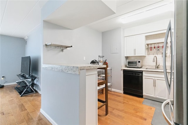 5 Bayard Rd Unit 206, Shadyside, PA 15213 - kitchen featuring dishwasher, a sink, freestanding refrigerator, a kitchen bar, and light wood-type flooring