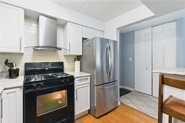 5 Bayard Rd Unit 206, Shadyside, PA 15213 - kitchen with gas stove, freestanding refrigerator, wall chimney exhaust hood, white cabinetry, and light wood-style flooring