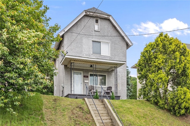 545 Ohio Ave, Midland Boro, PA 15059 - view of front facade with a porch, stucco siding, and a front yard