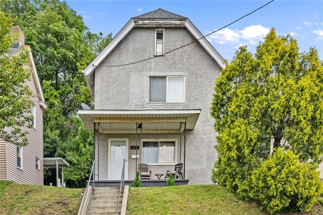 545 Ohio Ave, Midland Boro, PA 15059 - view of front of property with stucco siding, covered porch, and a front lawn