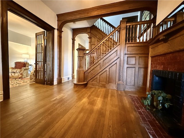 715 Chislett, East Liberty, PA 15206 - unfurnished living room featuring wood finished floors, stairs, a tile fireplace, and arched walkways