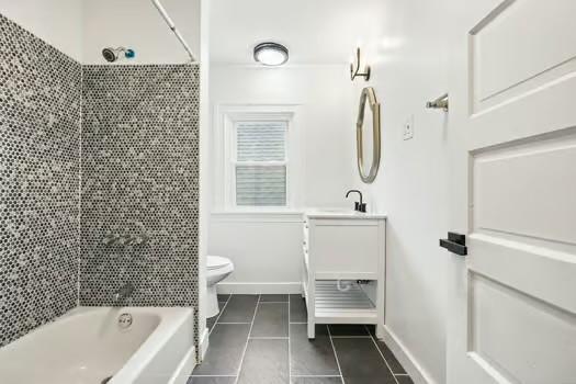 715 Chislett, East Liberty, PA 15206 - full bath featuring tile patterned flooring, toilet, vanity, bathing tub / shower combination, and baseboards