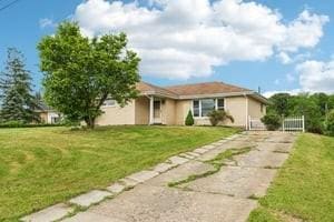 200 Edgewood Dr, Hopewell Twp Bea, PA 15001 - view of front of house with concrete driveway, a front lawn, and stucco siding