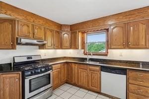 200 Edgewood Dr, Hopewell Twp Bea, PA 15001 - kitchen with dishwasher, stainless steel range with gas stovetop, under cabinet range hood, dark countertops, and brown cabinetry