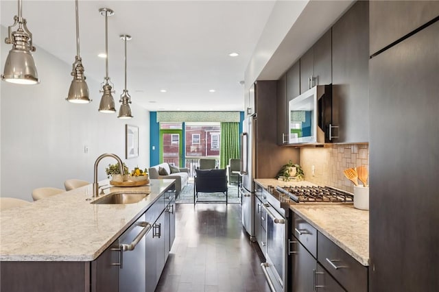 4707 Hatfield St, Lawrenceville, PA 15201 - kitchen featuring stainless steel appliances, dark wood-type flooring, decorative backsplash, dark brown cabinets, and open floor plan