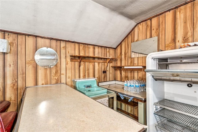 2554 Rte 259, Fairfield Twp, PA 15923 - kitchen featuring lofted ceiling, wood walls, brown cabinets, and a textured ceiling