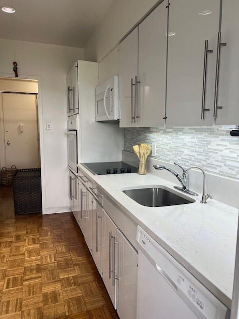 320 Fort Duquesne Blvd Unit 18F, Downtown Pgh, PA 15222 - kitchen with white appliances, light countertops, a sink, white cabinets, and recessed lighting