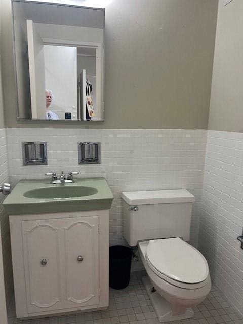 320 Fort Duquesne Blvd Unit 18F, Downtown Pgh, PA 15222 - bathroom featuring vanity, toilet, tile walls, wainscoting, and tile patterned flooring