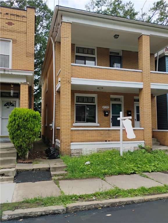 2759 Glen Mawr St, Sheraden, PA 15204 - view of front of house with a balcony, brick siding, and covered porch