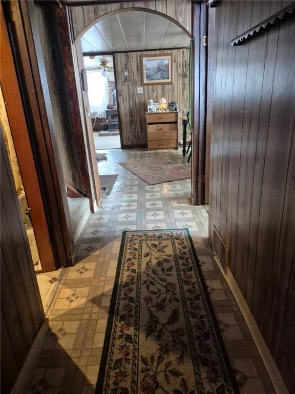 29564 Lake Creek Rd, Pa, PA 16314 - hallway featuring tile patterned floors, wood walls, and arched walkways