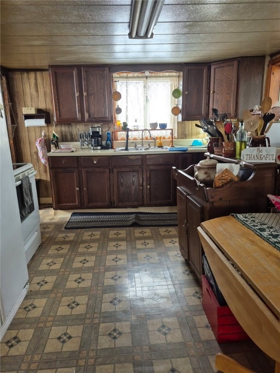 29564 Lake Creek Rd, Pa, PA 16314 - kitchen featuring a sink, white range with electric stovetop, tile patterned floors, light countertops, and wooden walls