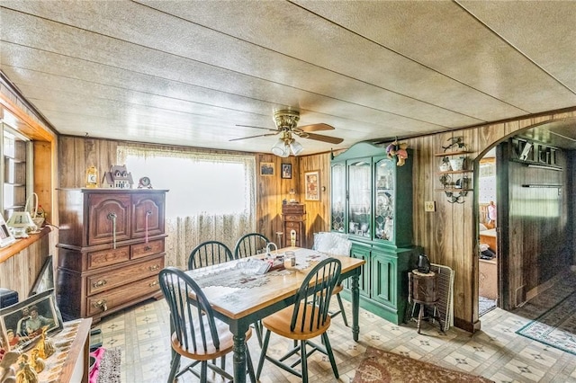 29564 Lake Creek Rd, Pa, PA 16314 - dining space featuring wooden walls, light flooring, arched walkways, and ceiling fan