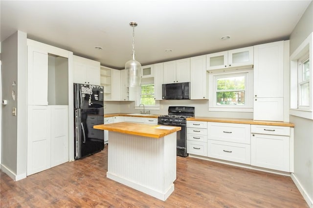 1017 Olive Ave, Natrona Hts/Harrison Twp, PA 15065 - kitchen with butcher block counters, black appliances, healthy amount of natural light, and glass insert cabinets