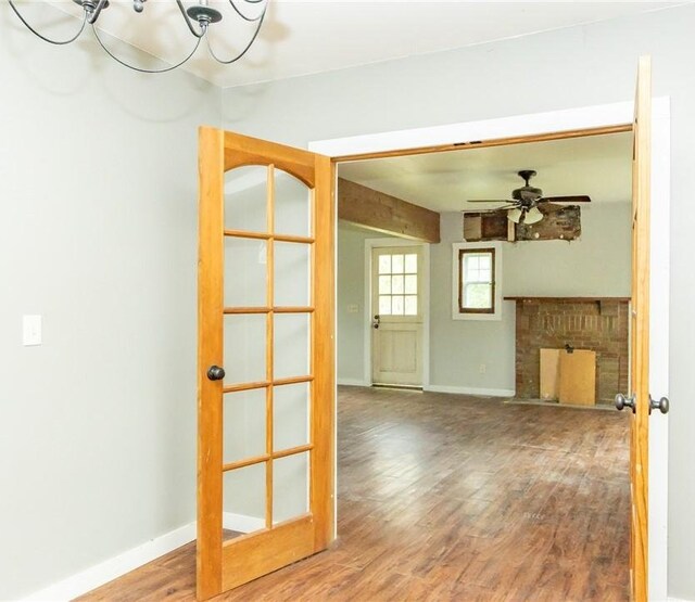 1017 Olive Ave, Natrona Hts/Harrison Twp, PA 15065 - unfurnished living room with wood finished floors, a brick fireplace, a ceiling fan, and baseboards