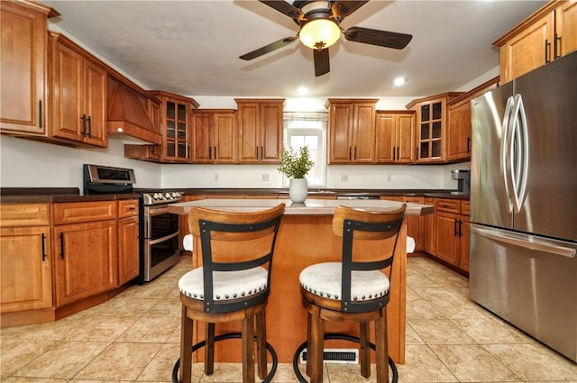 1726 Kennedy, Elizabeth Twp/Boro, PA 15018 - kitchen featuring appliances with stainless steel finishes, custom exhaust hood, brown cabinetry, a center island, and ceiling fan