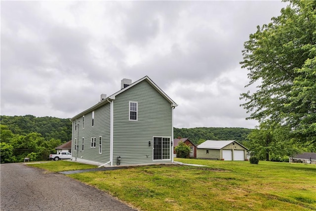 46 Terrace Rd, East Bethlehem, PA 15348 - view of property exterior featuring a chimney, a garage, a yard, and a forest view
